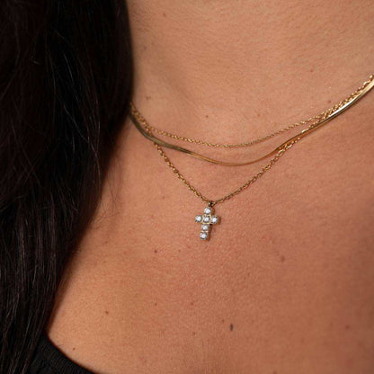 small gold cross necklace with CZ stones on 316L stainless steel chain worn on neck